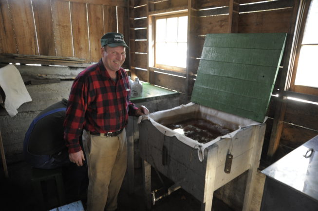 Haskell Yancey stands with syrup ready for canning, 2010.