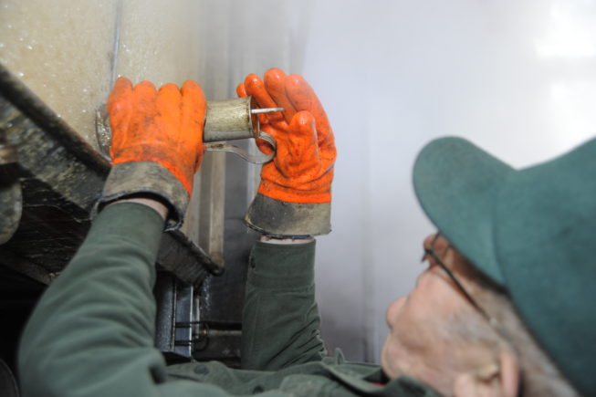 Gauging the sap being boiled into syrup in the evaporator, 2010.