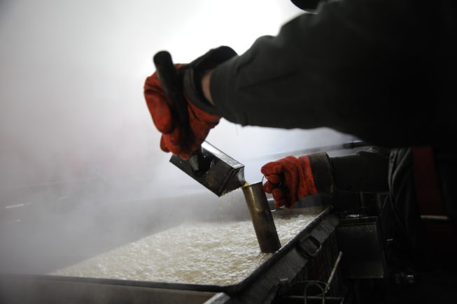 Gauging the sap being boiled into syrup in the evaporator, 2010.