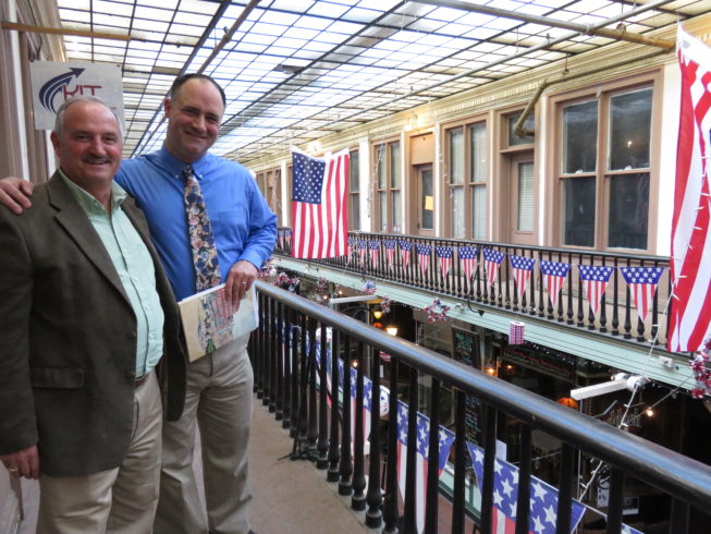 Steve Duffany, who is one of the longest-standing proprietors (as of 2017) with his insurance business in the Arcade, and Dr. Jason White, a local history buff and friend of the Paddock Arcade community, show visiting folklorists around the upper level during documentation for the award. Photo by Camilla Ammirati, 2017.