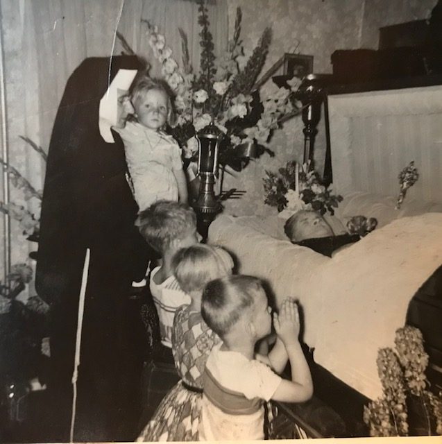 Loretta (kneeling) and siblings with their aunt, Sister Regis, at their grandmother “Babcah”’s wake in her farm house in Westernville, NY. In keeping with local tradition, both Loretta’s maternal grandparents’ caskets were laid out in the parlor at home. Photographer unknown, 1958. Courtesy of Loretta Lepkowski.